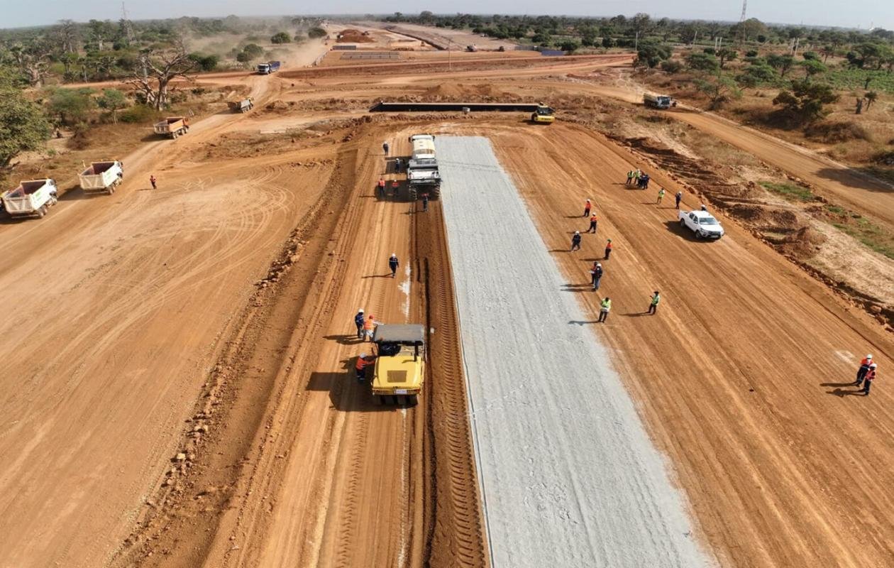 Travaux de construction sur l’autoroute Dakar–Tivaouane–Saint-Louis, machines et ouvriers sur le chantier.