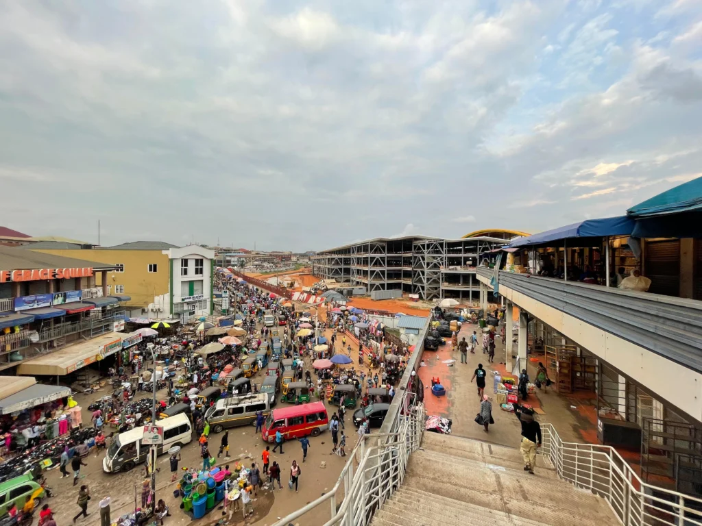 Vue du marché de Kejetia à Kumasi, au Ghana, avec les étals et l’activité commerciale.